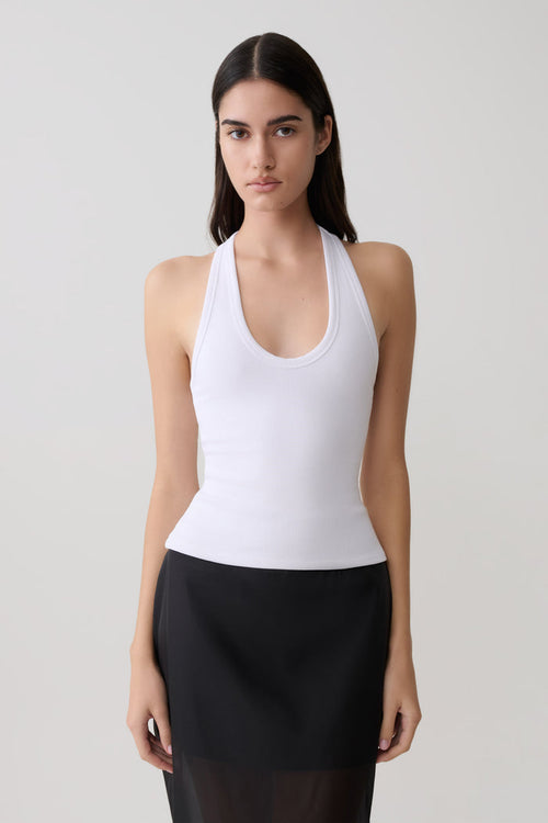 Woman wearing a white ribbed tank.