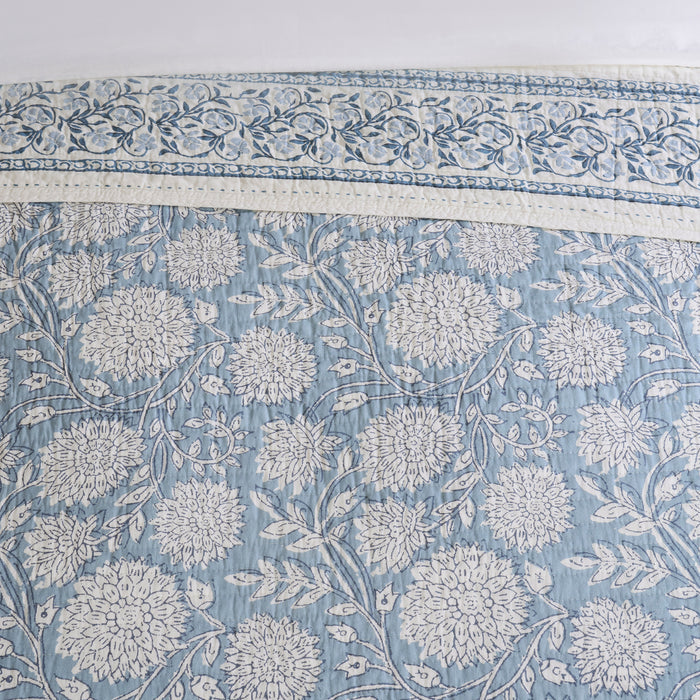 Floral patterned fabric with intricate design on a light blue background