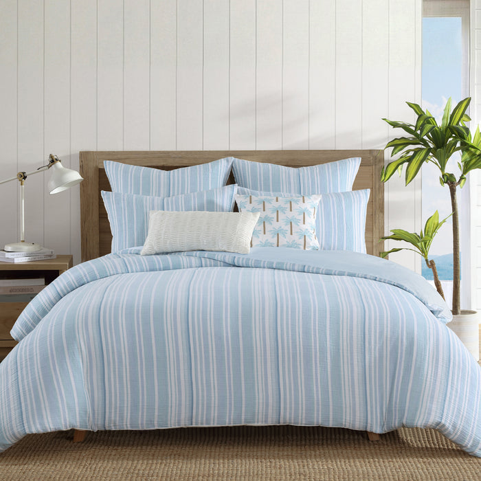 Boracay Stripe Muslin Duvet Cover Set displayed on a bed with striped aqua and white bedding, creating a coastal bedroom look.