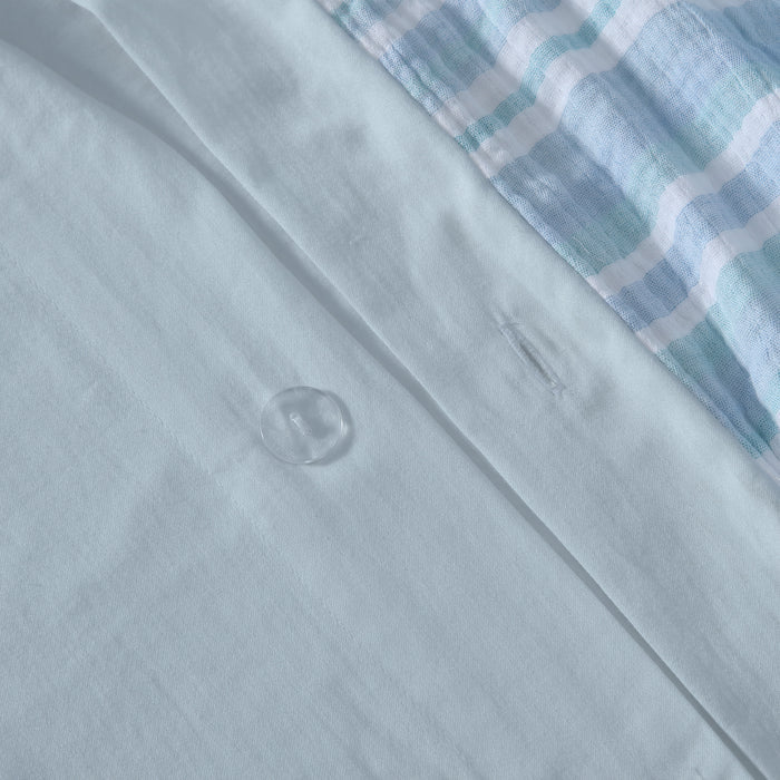 Close-up of the Boracay Stripe Muslin Duvet Cover Set featuring soft aqua fabric and button detail.