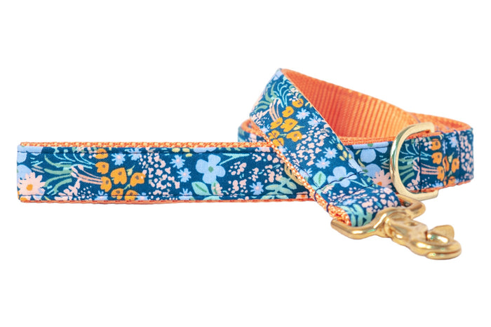 Bursting with color, this floral dog leash features a navy background with vibrant blooms, plus polished hardware and nylon lining for a sunny statement look.