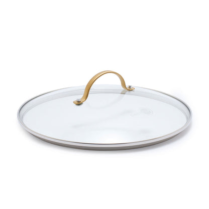 Tempered glass lid with matte gold handle, shown angled on a white background.
