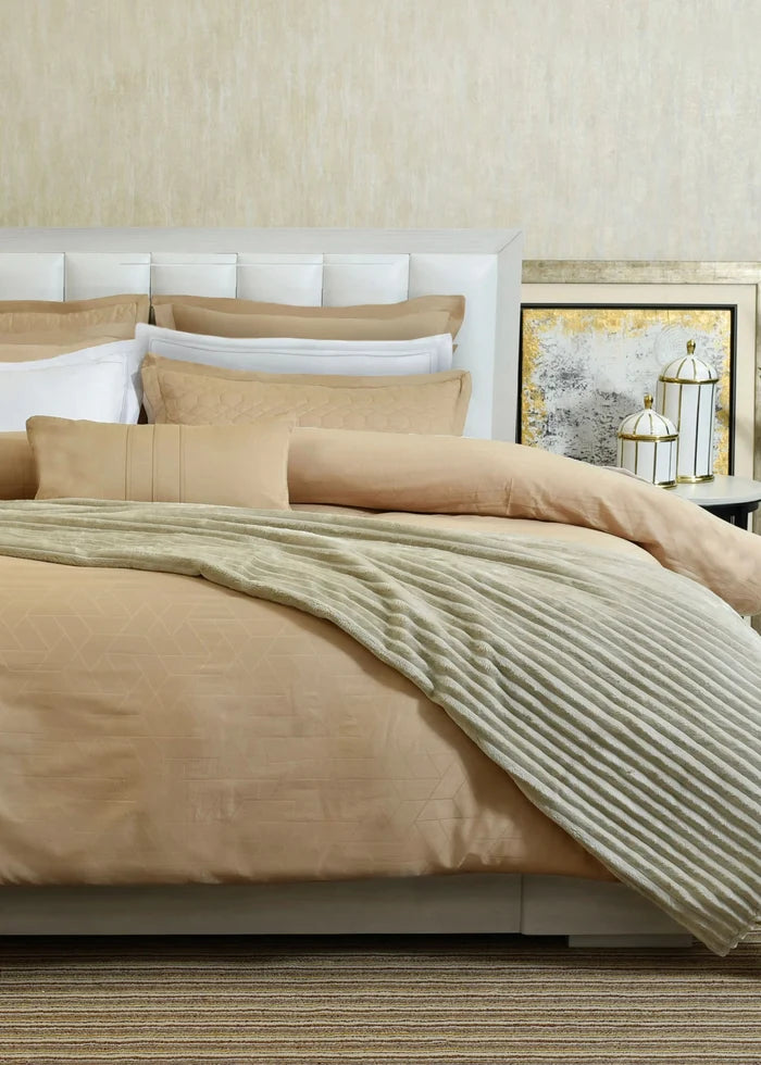 Butter cotton sateen duvet cover set on bed with pillow shams and striped bed sheet
