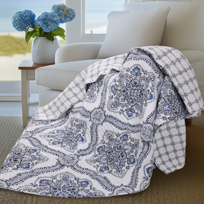 Lentana Navy Quilted Throw draped over a chair, featuring intricate medallion pattern and subtle grid design.
