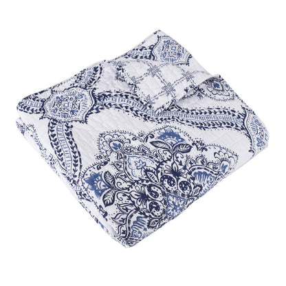 Lentana Navy Quilted Throw featuring intricate medallion pattern in navy and white, perfect for cozying up on the couch.