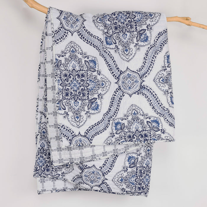 Lentana Navy Quilted Throw showcasing intricate medallion pattern in navy and white, perfect for cozy decor.