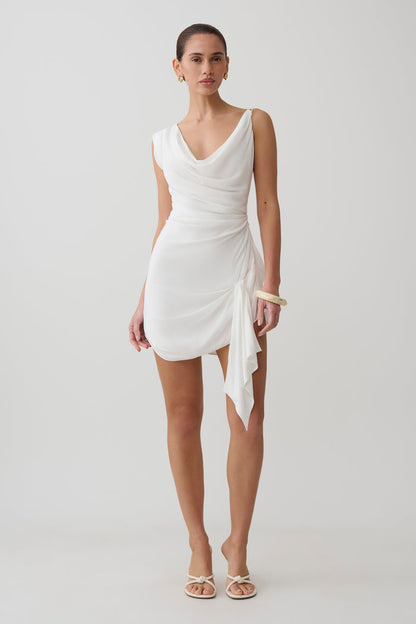 Woman wearing a white cowl drape satin mini dress.