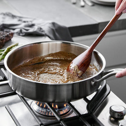 Brown sauce being stirred in a Merten  Storck 3.5-quart stainless steel sauté pan on a stovetop.