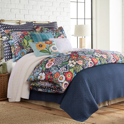 Bed with colorful floral bedding and pillows in a bedroom setting.