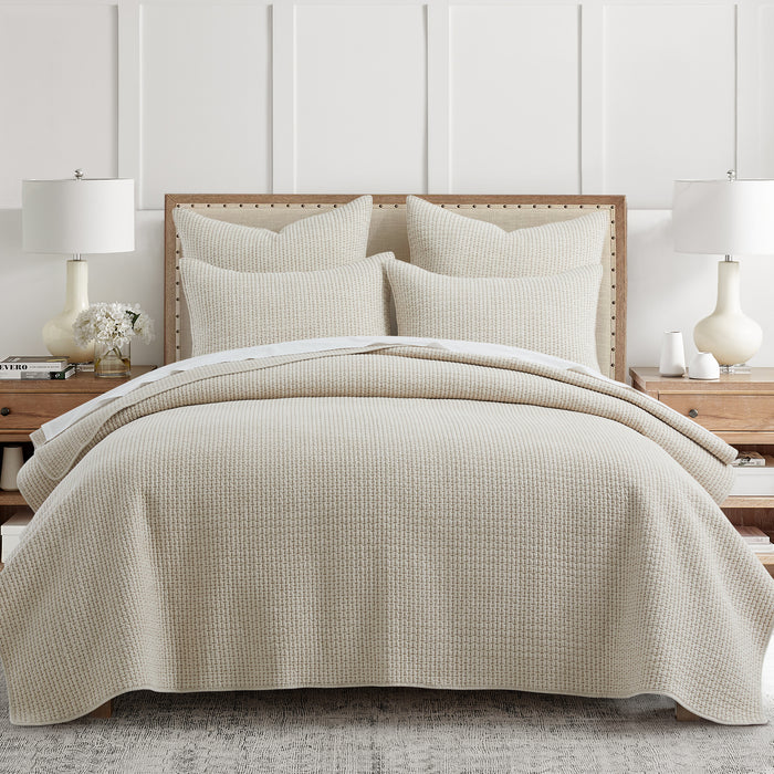 Pick-Stitch Artisan Quilt Set in light beige on a bed with matching shams and modern decor.