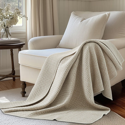 Pick-Stitch Artisan Quilted Throw draped on a cozy sofa, showcasing its handcrafted texture and light color.