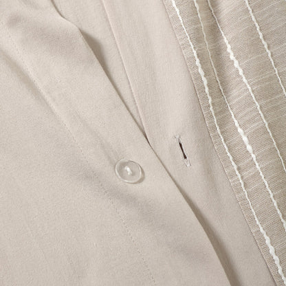 Close-up of a beige fabric with a button and white stripe detail