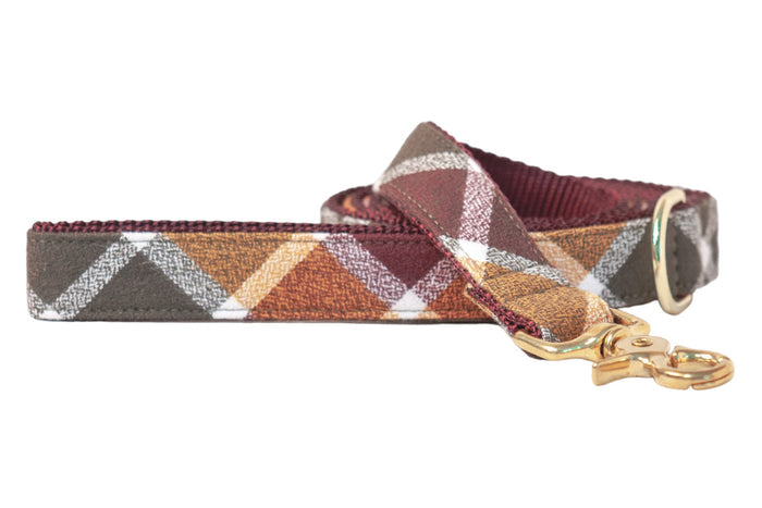 Dog leash in rich autumn plaid, made from flannel fabric with reinforced stitching, a  swivel clasp, and a matching D-ring near the handle loop.