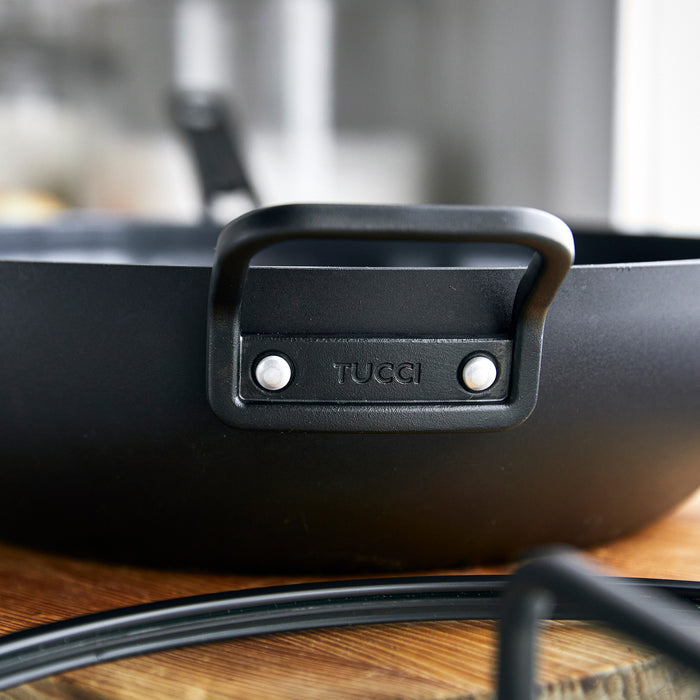Milano Black ceramic nonstick 6.5-quart pan with handles, close-up of surface and rim details.