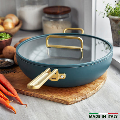 Venetian teal ceramic pan, 6.5QT size, on a board surrounded by assorted vegetables and kitchen utensils.