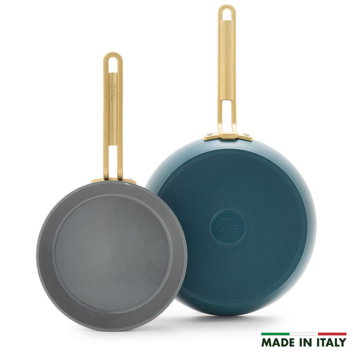 Two Stanley Tucci™ Ceramic Nonstick frypans (8" & 10") with gold handles—one displaying the cooking surface, the other its Venetian Teal bottom. PFAS-free and MADE IN ITALY text with Italian flag appear at lower right.