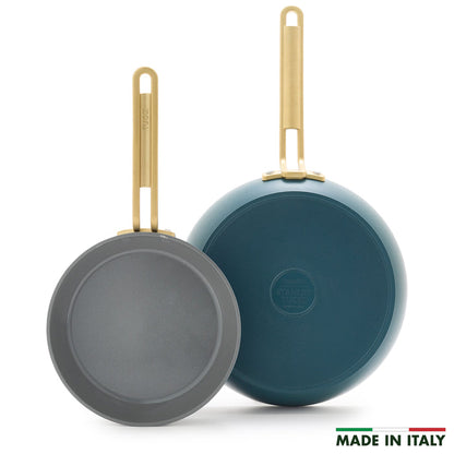 Two Stanley Tucci™ Ceramic Nonstick frypans (8" & 10") with gold handles—one displaying the cooking surface, the other its Venetian Teal bottom. PFAS-free and MADE IN ITALY text with Italian flag appear at lower right.