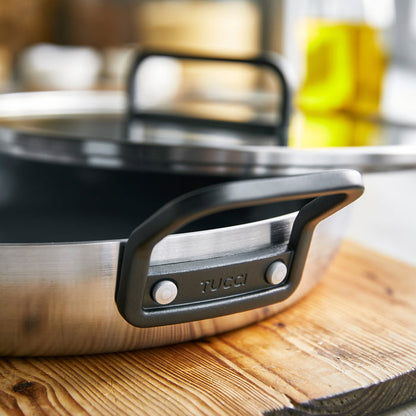 12-inch stainless steel frypan with ceramic nonstick surface and black handle, resting on a wood surface.