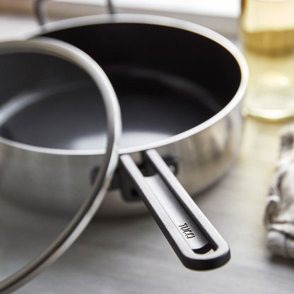 Stainless steel sauté pan with ceramic nonstick surface and lid, 4-quart size, on a kitchen counter.