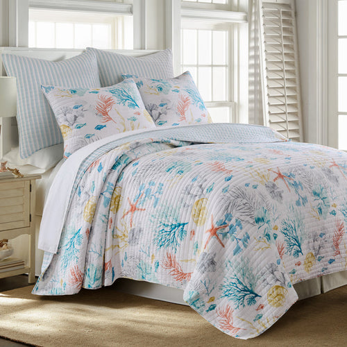Bed with floral-patterned bedding in a bright bedroom