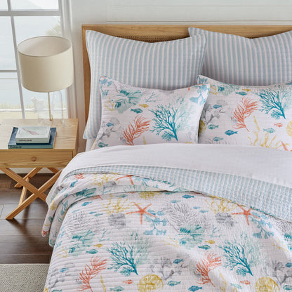 Bed with floral bedding and pillows in a bright room