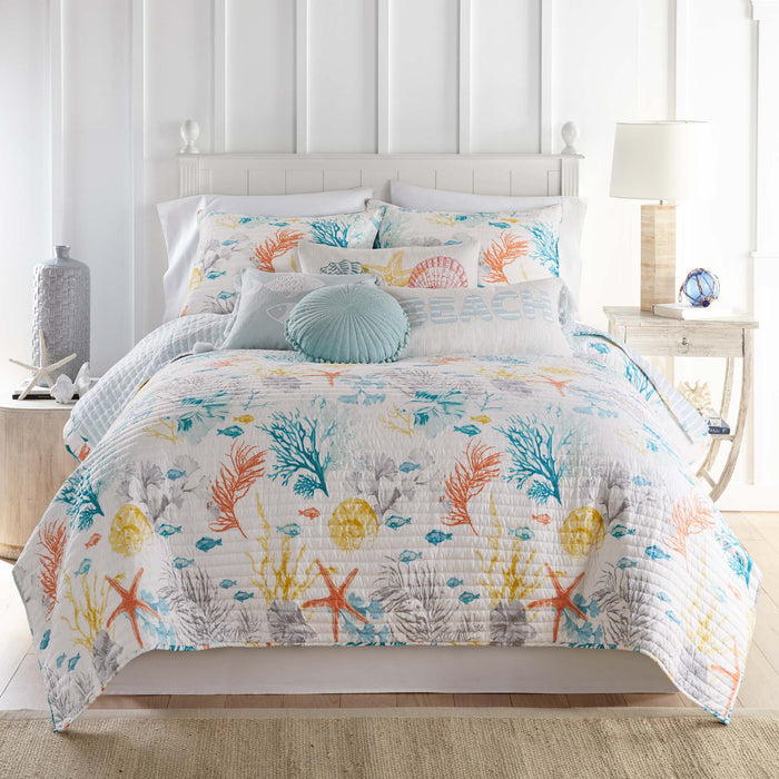 Bed with colorful floral patterned bedding in a bright room.