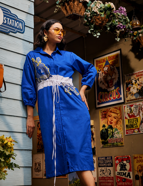 Wild Royal Blue Shirt Dress with abstract blue and yellow embroidery, contrasting white drawstring waist panel, and three-quarter sleeves in a chic relaxed silhouette.