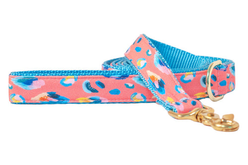 A bold dog leash with a coral pink base and abstract leopard spots, finished with a bright nylon lining and polished hardware.